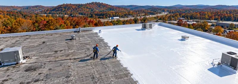 Aerial view of a roof being coated in white silicone